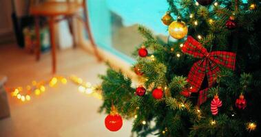 Christmas tree branch decorated with candy cane and baubles with blurred shiny lights on background photo