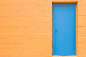 Closed blue wooden door on yellow wall background photo