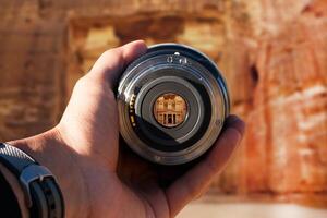 selective focus shot person holding camera lens on Petra tourist taking a picture with camera lens on Petra photo