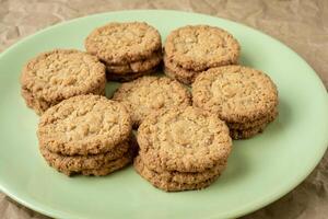 Tasty cookies biscuits. Stack of sugar cookies biscuits in green plate. photo