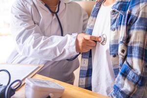 The doctor is listening to the patient's heart to find out the patient's condition as a treatment guide. photo