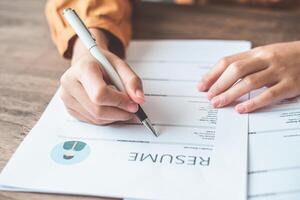 People are filling out their resume on the job application form to apply for a job at a company. photo