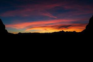 silueta oscura de montañas y puesta de sol. picos de montaña dolomitas. Brenta, Italia foto