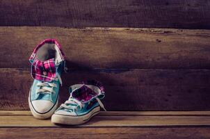 Sneakers on floor on wooden background photo