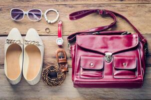 Shoes, handbags, accessories for women, placed on a wooden floor. photo