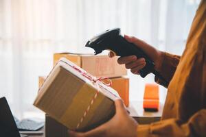 Delivery staff scanning cardboard box with barcode scanner to check products for customers photo