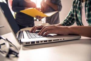 Business people work together to analyze problems, discuss business approaches with smartphone laptops, and office documents in sun glare effect photo