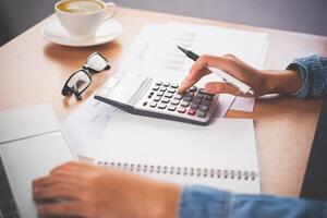 The accountant's hand is using the calculator. For cost analysis Profit and loss and tax calculation concept preparation of financial statements photo