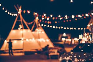 Blurred images of the background party in the festive festivities during the night, consisting of people and glittering bokeh. photo