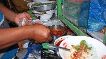 Soto seller prepares a menu at his stall photo