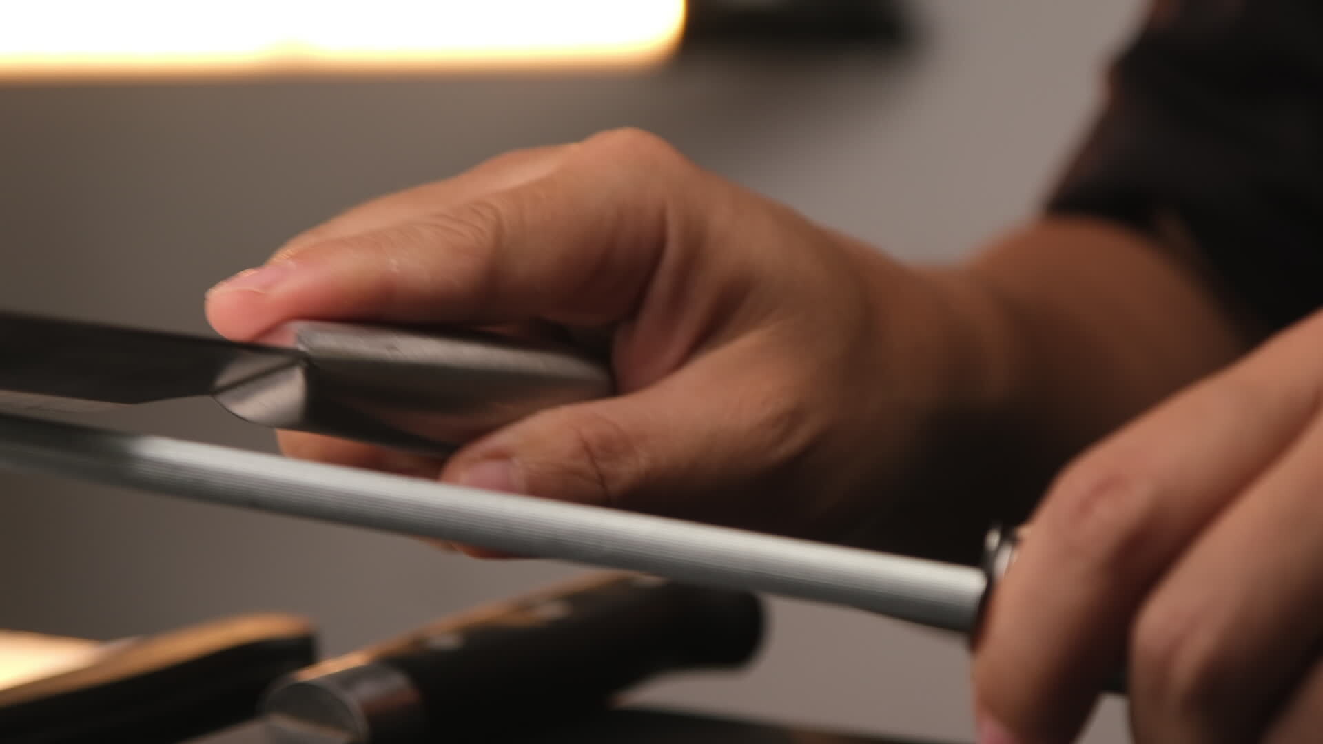 Closeup of female chef sharpening knives. Sharpen knives with a whetstone or grinding stone