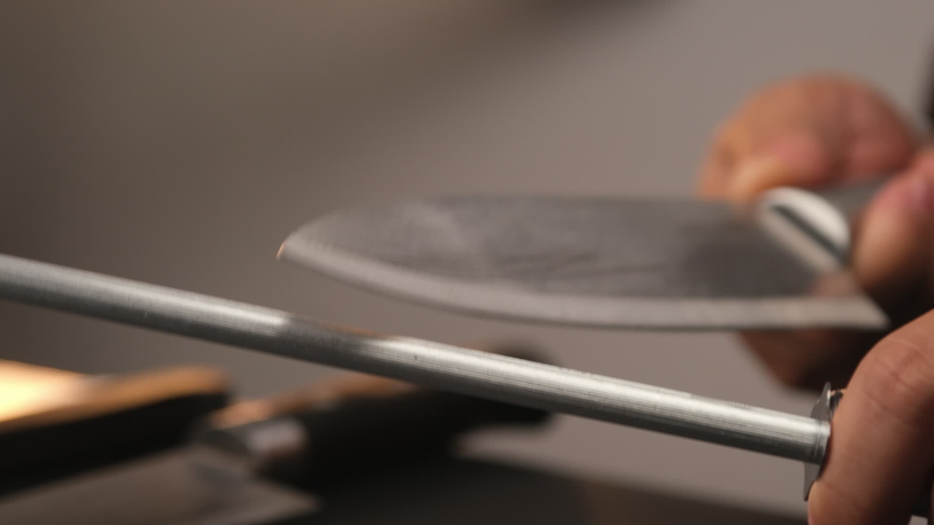Closeup of female chef sharpening knives. Sharpen knives with a whetstone or grinding stone