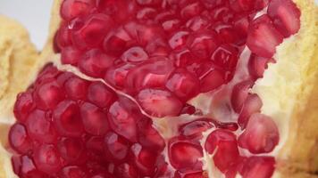 Fresh ripe pomegranate isolated on white background. close up of juicy pomegranate cut in half. Ripe fruit is a healthy food. video