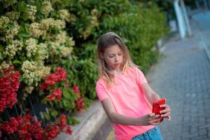 un joven niña es participación un rojo teléfono foto