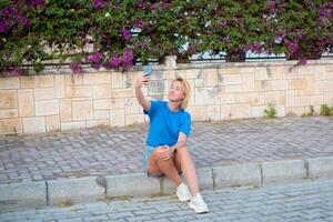 un mujer sentado en el bordillo tomando un selfie foto