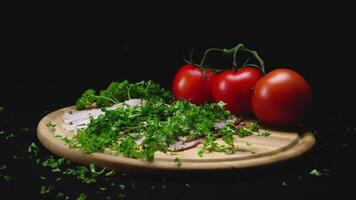 de cerca de ingredientes en de madera Cocinando tablero en negro aislado antecedentes. marco. puñado de verde fragante perejil vierte en rebanadas de carne. reemplazar graso carne con jugoso verduras video