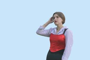 Stylish Caucasian girl in a white shirt and red top, isolated on a blue background. Free space for text. photo