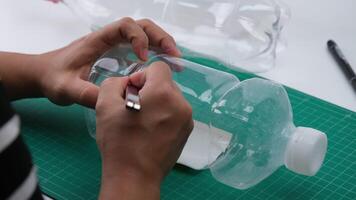 il processi di fabbricazione pianta pentole a partire dal plastica bottiglie. mano taglio un' plastica bottiglia con un' fresa per crescere impianti o verdure dentro. riciclare e riutilizzabile verde giardino concetto. video