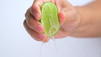 Female hand squeezing half fresh lemon isolated on white background. Squeezing fresh lemon close up. Hight Vitamin C Natural video