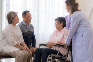 Asian young nurse support couple senior older woman in a wheelchair. elderly mature and a group of senior friends living in the hospital. socializing of retired people. photo