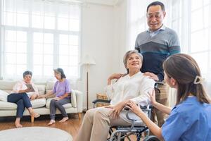 Asian young nurse support couple senior older man and woman in a wheelchair. elderly mature and a group of senior friends living in the hospital. socializing of retired people. photo