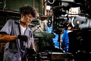 Engineer worker in production plant drilling at machine. Professional worker near drilling machine on factory. man inspecting and repairing machine for operation in workshop. photo