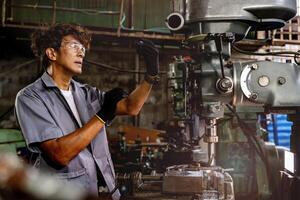 Engineer worker in production plant drilling at machine. Professional worker near drilling machine on factory. man inspecting and repairing machine for operation in workshop. photo