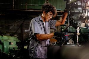 ingeniero trabajador en producción planta perforación a máquina. profesional trabajador cerca perforación máquina en fábrica. hombre inspeccionando y reparando máquina para operación en taller. foto