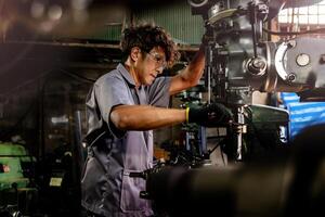 ingeniero trabajador en producción planta perforación a máquina. profesional trabajador cerca perforación máquina en fábrica. hombre inspeccionando y reparando máquina para operación en taller. foto