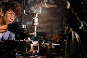 Engineer worker in production plant drilling at machine. Professional worker near drilling machine on factory. man inspecting and repairing machine for operation in workshop. photo