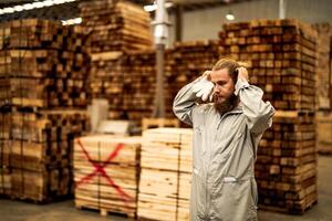 man workers engineering standing with confidence with working suite dress and hand glove in front machine. Concept of smart industry worker operating. Wood factory produce wood palate. photo