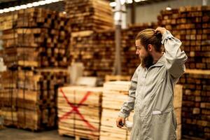 man workers engineering standing with confidence with working suite dress and hand glove in front machine. Concept of smart industry worker operating. Wood factory produce wood palate. photo