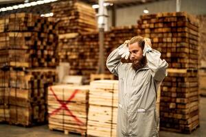 man workers engineering standing with confidence with working suite dress and hand glove in front machine. Concept of smart industry worker operating. Wood factory produce wood palate. photo