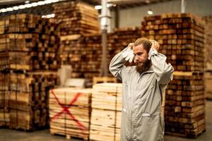 man workers engineering standing with confidence with working suite dress and hand glove in front machine. Concept of smart industry worker operating. Wood factory produce wood palate. photo