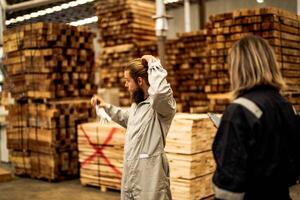 man workers engineering standing with confidence with working suite dress and hand glove in front machine. Concept of smart industry worker operating. Wood factory produce wood palate. photo