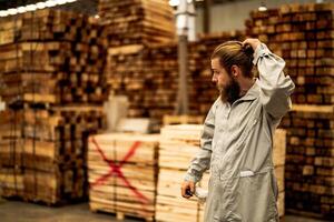man workers engineering standing with confidence with working suite dress and hand glove in front machine. Concept of smart industry worker operating. Wood factory produce wood palate. photo