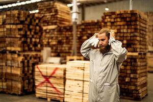 man workers engineering standing with confidence with working suite dress and hand glove in front machine. Concept of smart industry worker operating. Wood factory produce wood palate. photo