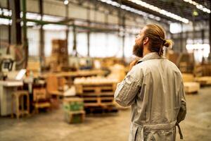 man workers engineering standing with confidence with working suite dress and hand glove in front machine. Concept of smart industry worker operating. Wood factory produce wood palate. photo