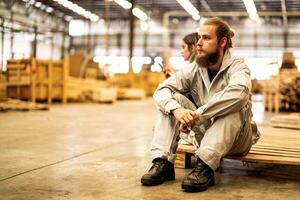 hombre trabajadores Ingenieria sentado con confianza con trabajando suite vestir y mano guante en frente máquina. concepto de inteligente industria trabajador operando. madera fábrica Produce madera paladar. foto