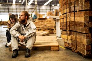 man workers engineering sitting with confidence with working suite dress and hand glove in front machine. Concept of smart industry worker operating. Wood factory produce wood palate. photo