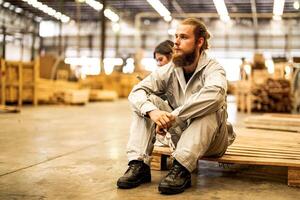 hombre trabajadores Ingenieria sentado con confianza con trabajando suite vestir y mano guante en frente máquina. concepto de inteligente industria trabajador operando. madera fábrica Produce madera paladar. foto