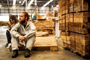 man workers engineering sitting with confidence with working suite dress and hand glove in front machine. Concept of smart industry worker operating. Wood factory produce wood palate. photo