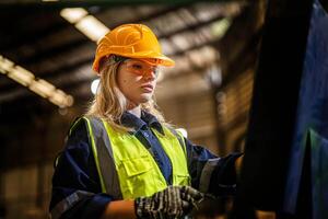 fábrica ingeniero mujer en pie confianza a controlar panel cambiar. trabajador trabajos a pesado máquina a industria fábrica. con maquinaria equipo planta tecnología. inteligente industria trabajador operando. foto