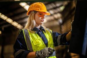 fábrica ingeniero mujer en pie confianza a controlar panel cambiar. trabajador trabajos a pesado máquina a industria fábrica. con maquinaria equipo planta tecnología. inteligente industria trabajador operando. foto