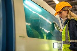 Factory engineer woman standing confidence to control panel switch. Worker works at heavy machine at industry factory. with machinery equipment plant technology. smart industry worker operating. photo