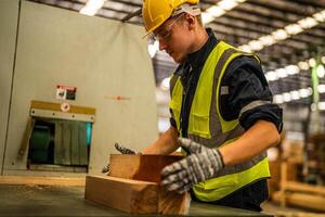 Factory engineer man working with timber material. Worker works at heavy machine at industry factory. with machinery equipment plant technology. smart industry worker operating. photo