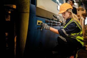 Factory engineer woman standing confidence to control panel switch. Worker works at heavy machine at industry factory. with machinery equipment plant technology. smart industry worker operating. photo