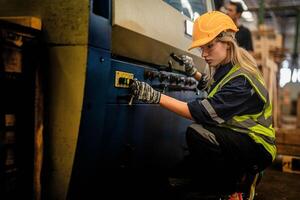 Factory engineer woman standing confidence to control panel switch. Worker works at heavy machine at industry factory. with machinery equipment plant technology. smart industry worker operating. photo