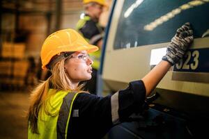 Factory engineer woman standing confidence to control panel switch. Worker works at heavy machine at industry factory. with machinery equipment plant technology. smart industry worker operating. photo