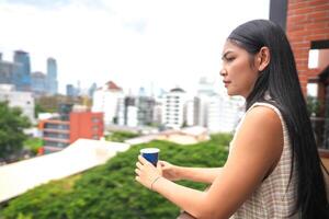 African business smart woman stands at outdoor terrace building. people with on hand in good feeling with city space building. relaxing of people business morning. photo